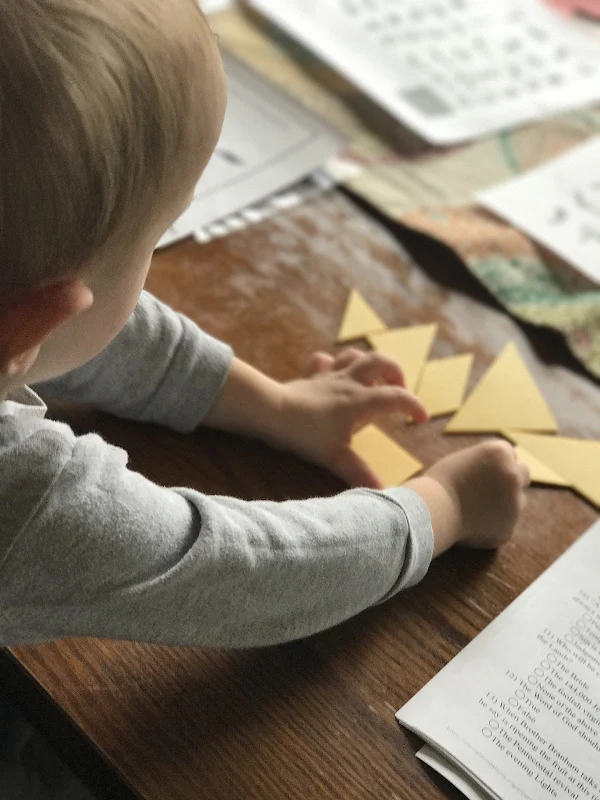 Veja as peças do tangram nas mãos da criança