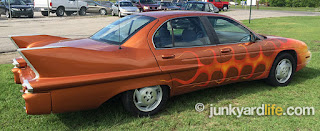 Wild paint and Cadillac fins cover a 1995 family sedan made by Chevrolet.
