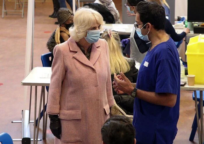 The Duchess met with those involved in the vaccination process, including NHS staff, volunteers and representatives. Pink wool coat and black boot