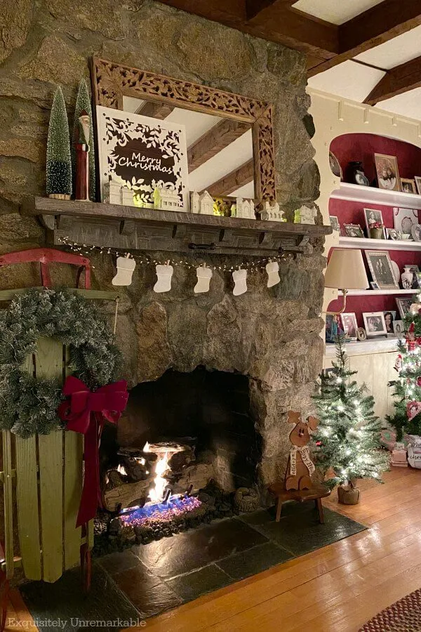 Stone Fireplace decorated for Christmas with tiny stocking banner