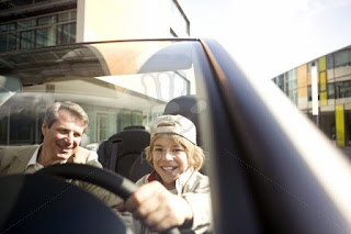 Father and long hair son driving a Car.