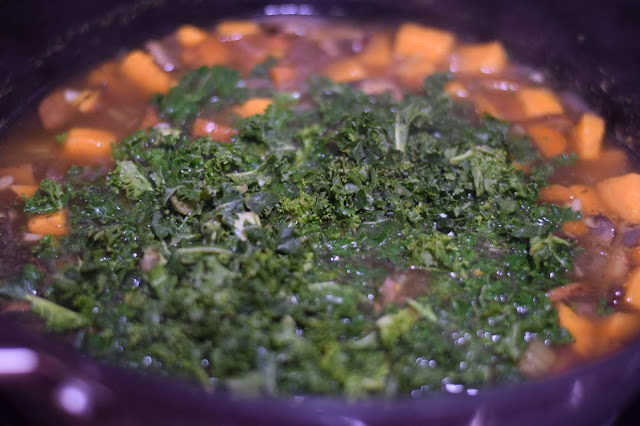 The kale being added to the pot. 