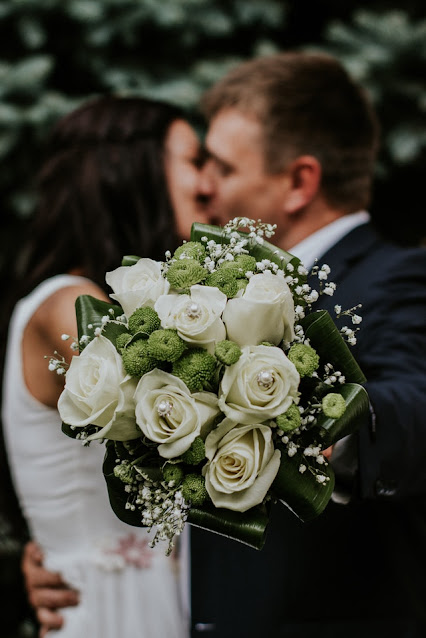 A couple kissing and holding Flowers