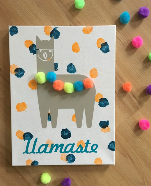 Add a touch of whimsy to a nursery with DIY painted llama pom pom wall art made with vinyl and Cricut.