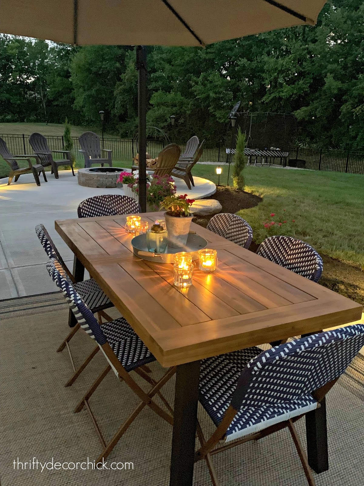 Wood outdoor dining table with blue and white chairs