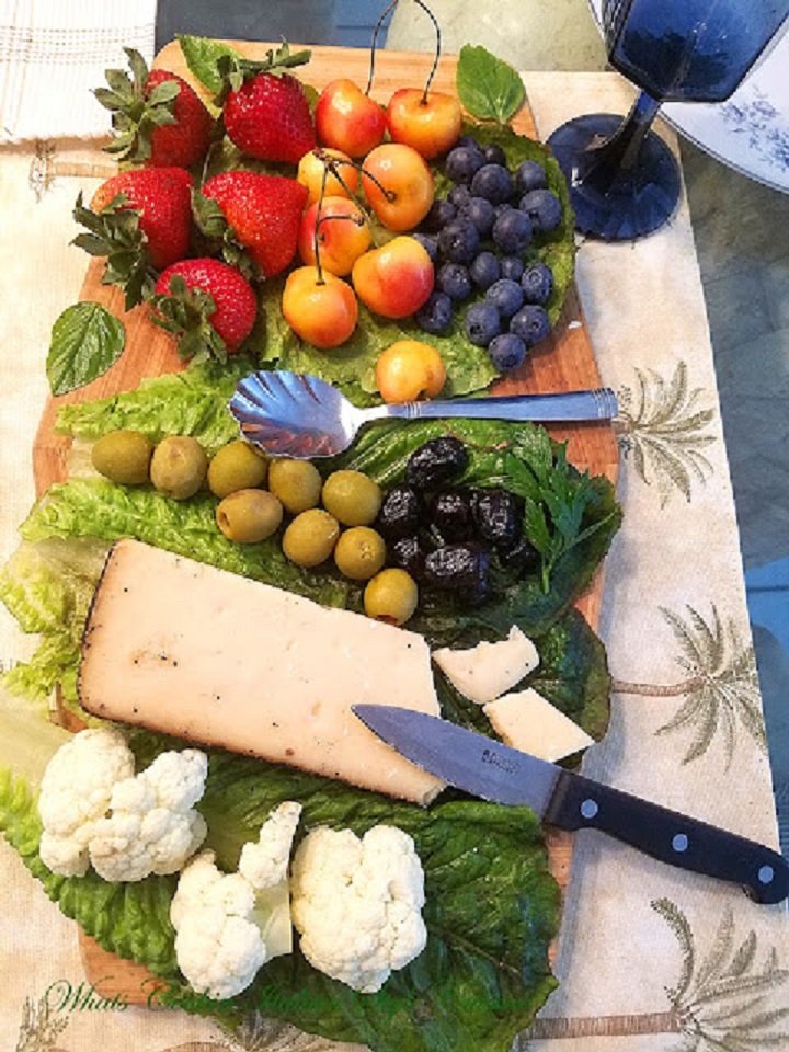 This is a cheese, wine, fruit, olives and board built with all kinds of appetizers to include raw and washed fruits and vegetables