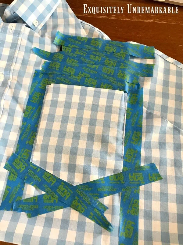 Taping Off The Pocket of a blue gingham shirt in preparation to paint