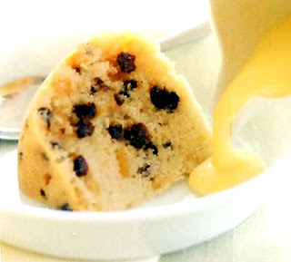 spotted dick steamed pudding served with custard in a white bowl