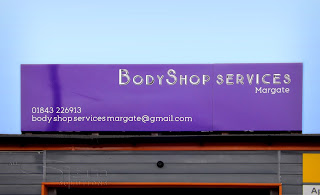 Purple board with white vinyl text over the top of the workshop.