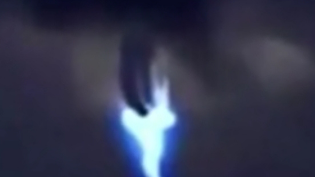 Alien UFO with electric blue beam coming from it.