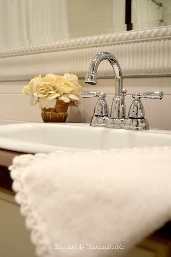 White towel hanging off of wooden countertop in bathroom