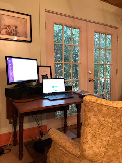 a computer desk in front of French doors