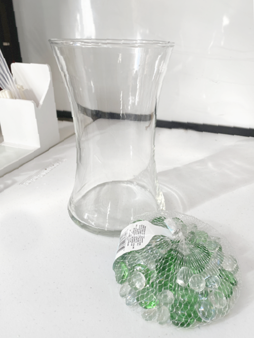 glass vase and package of green and clear bead gems