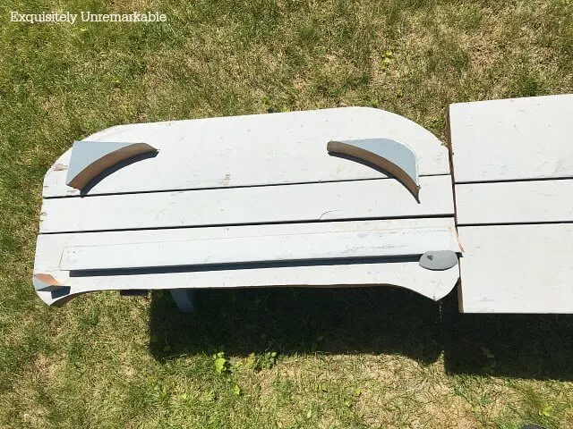 Wooden bench with curves cut and wooden scraps on top of it