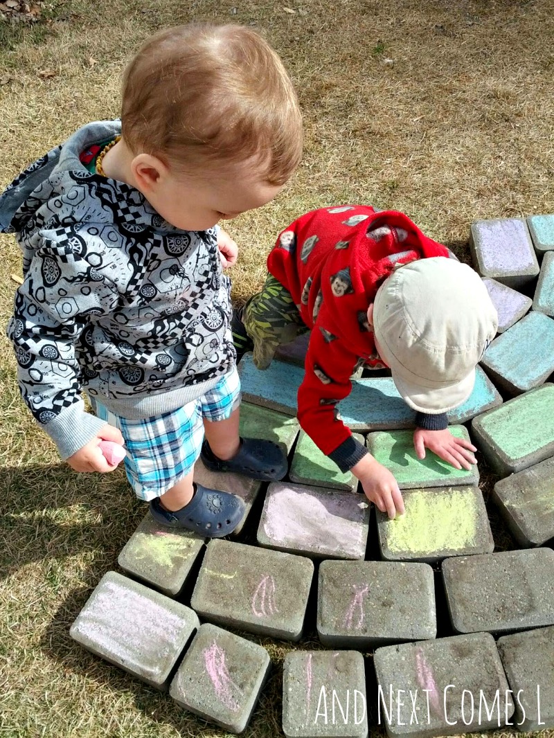 Sibling play: coloring a giant chalk rainbow together from And Next Comes L
