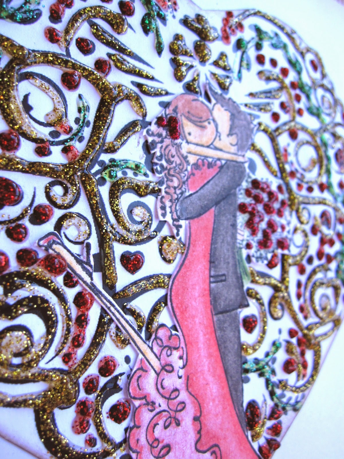otro detalle de tarjeta de scrapbooking para San Valentín con corazón de filigrana decorado con glitter glue rojo, verde y amarillo y pareja de novios coloreada besándose