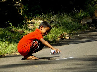 anak mengecat jalan yang berlubang dengn uang hasil tabunganya
