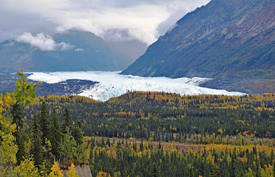 Alaska glacier with forest mountain and clouds