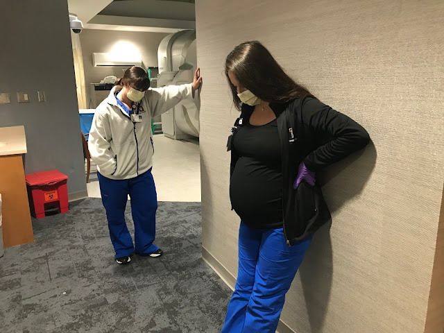 Two healthcare workers lean against a wall