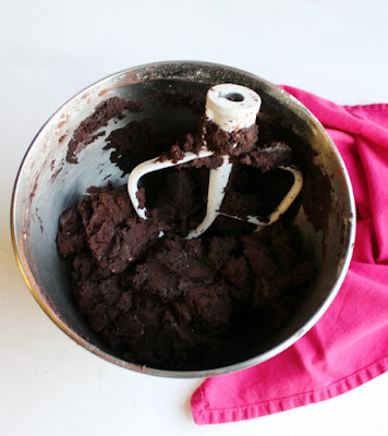 bowl of dark chocolate cookie dough with mixer paddle