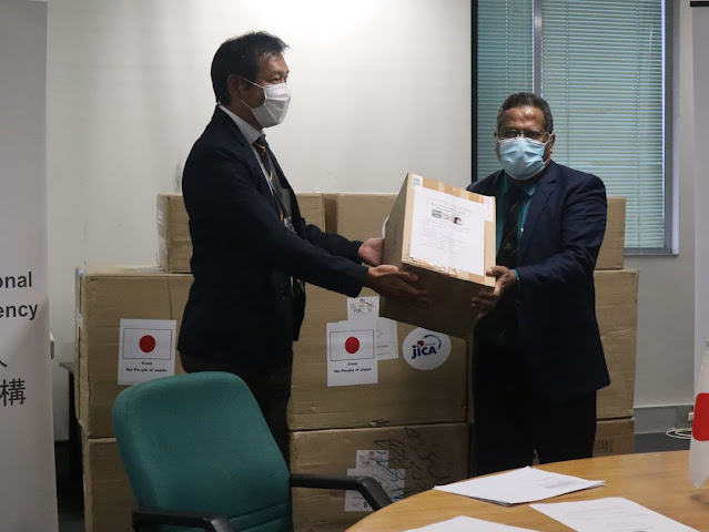 PNG Deputy Controller for National Pandemic Response Dr Paison Dakulala  receiving a donation of masks from Japanese International Cooperation Agency