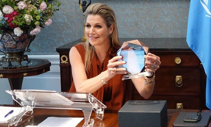 Queen Maxima wore a brow silk sleeveless tie-bow blouse from Natan. black diamond earrings. EMERGE Financial Health conference