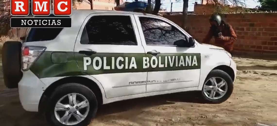 El auto patrullero aparece en la imagen en el momento en que trata de embestir al periodista de televisión / RMC - HOLA TARIJA