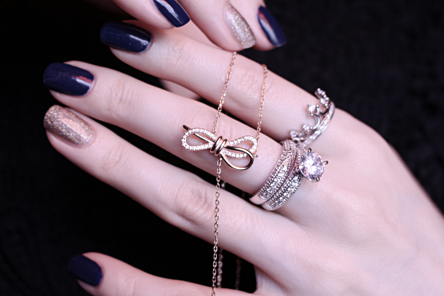 close-up of a woman's hand holding few silver jewelry pieces