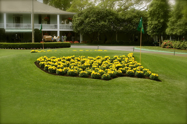 Augusta National logo in flowers with clubhouse in background