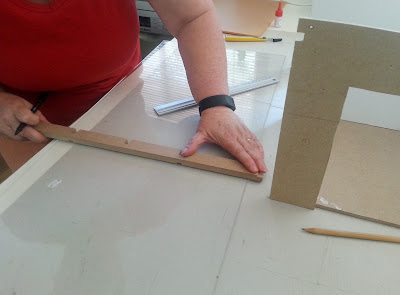 Person measuring a piece of perspex.