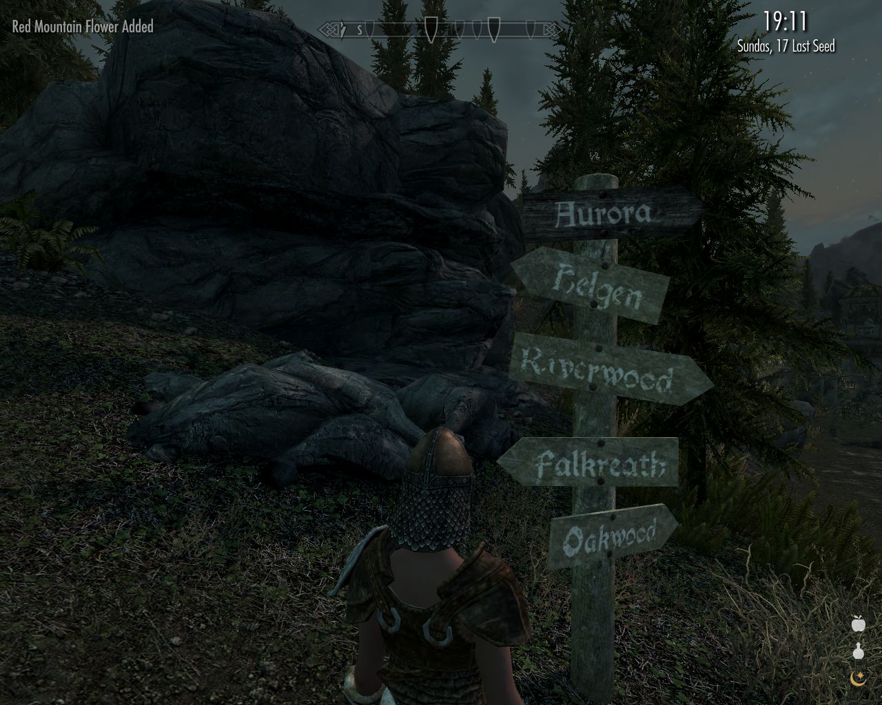 evening, Laura stands in front of a post with signs pointing to various settlements
