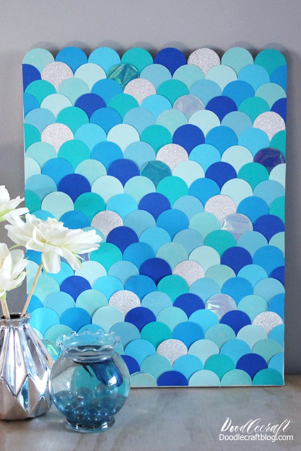 The different shades of blues, the glitter paper and the iridescent shimmer make this mermaid scale wall art the perfect home decor or party decoration.