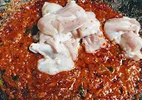Adding chicken pieces in ghee roast masala for chicken ghee roast recipe