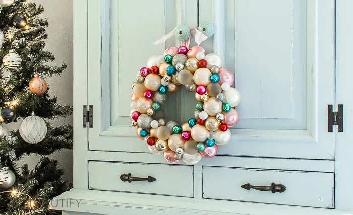pastel ornament ball wreath hanging on cabinet