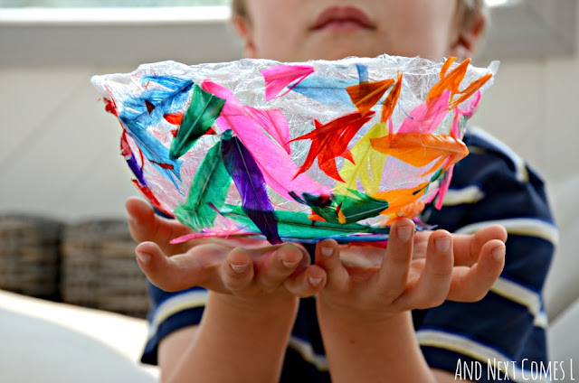 A child holding a homemade feather bowl craft