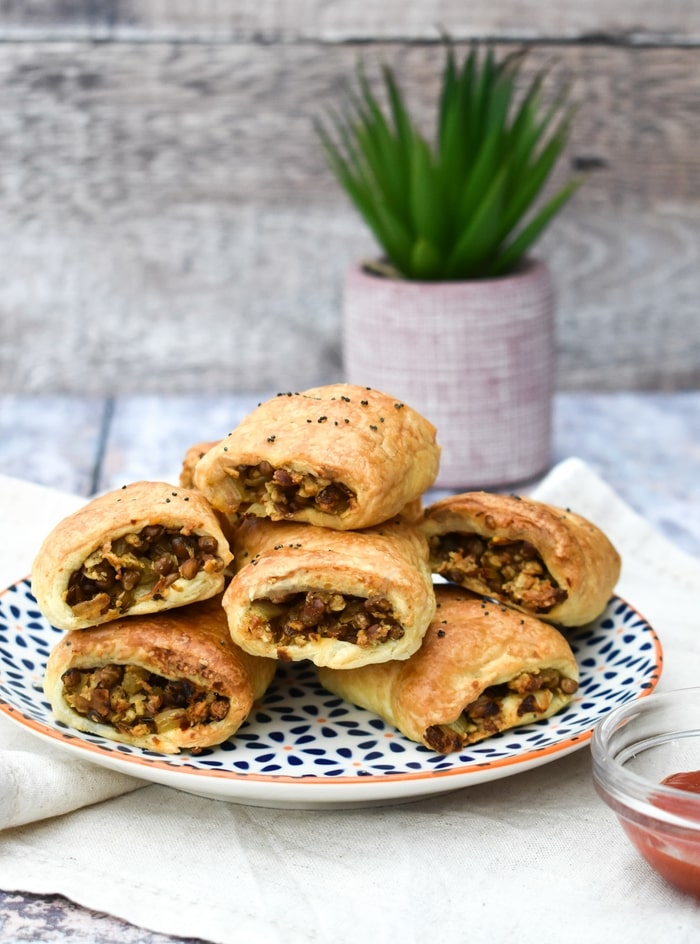 Vegan sausage rolls, stacked on a plate