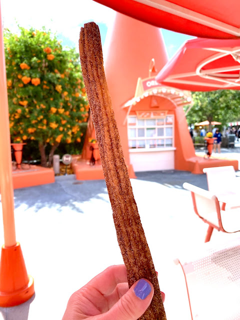 Holding the Milk and Cookies churro in front of the Cozy Cone Motel in Cars Land at California Adventure.