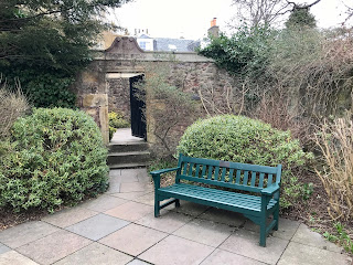 Tomb of John Livingstone, Edinburgh.  The forecourt of the tomb looks like a well kept residential garden and is paved with neat bushes and a green garden bench.  Photo by Kevin Nosferatu for the Skulferatu Project.