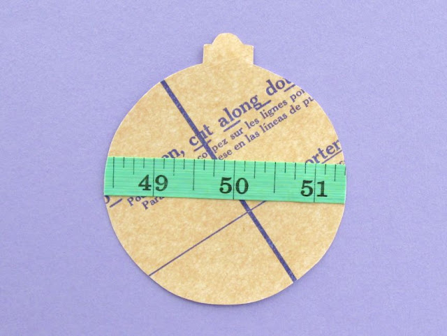 Crafty Christmas Bauble Tutorial: Make a Sewing-Themed Ornament for Your Tree! Paper bauble decorated with sewing pattern and measuring tape