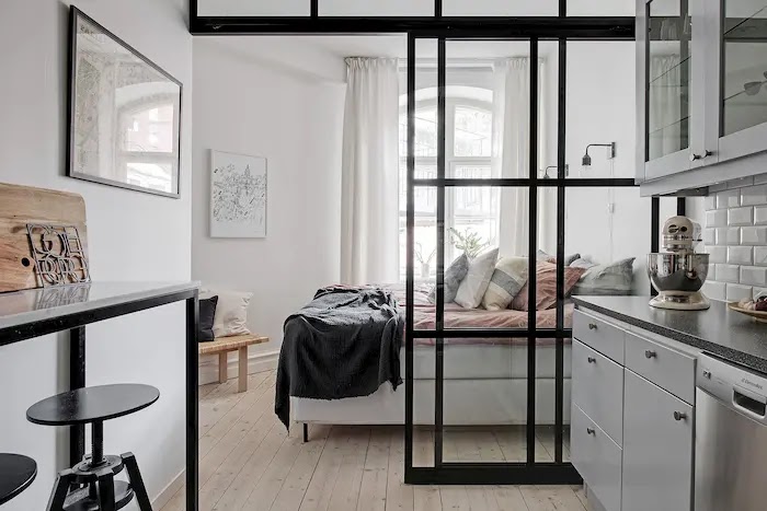 Trucos para aprovechar mejor el espacio en casas pequeñas Puerta corredera de vidrio y hierro entre la cocina y el dormitorio de un apartamento pequeño