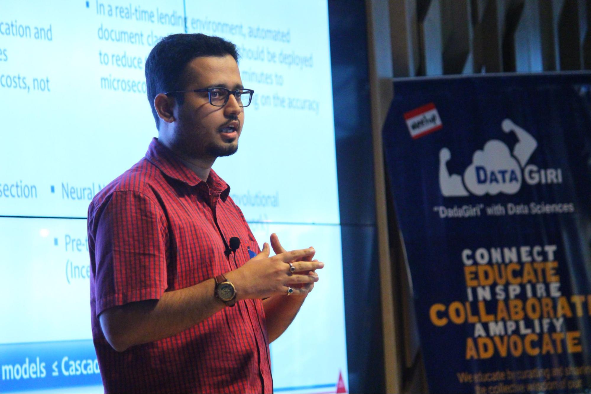 Image shows Bhavesh Bhatt onstage giving a presentation