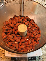 Raw almonds in food processor. https://trimazing.com/ Photo of 4 cups of raw almonds in a food processor bowl. https://trimazing.com/