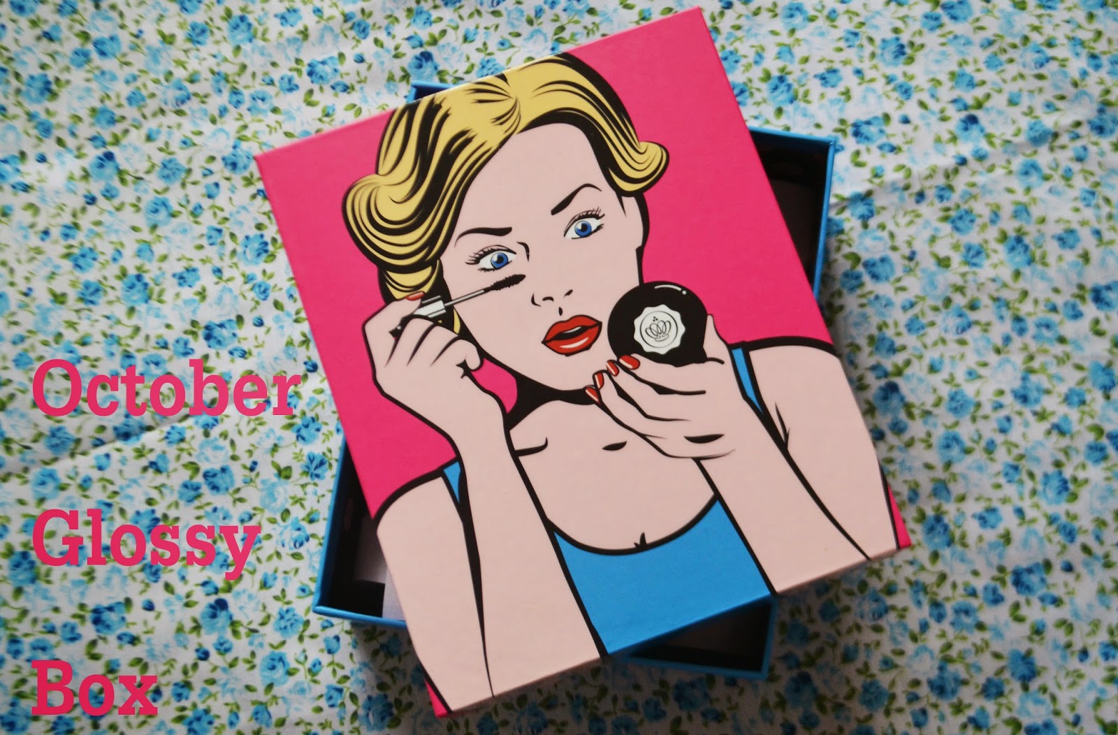 The lid of the October Glossybox. The october box has a comic book style cartoon girl on the front