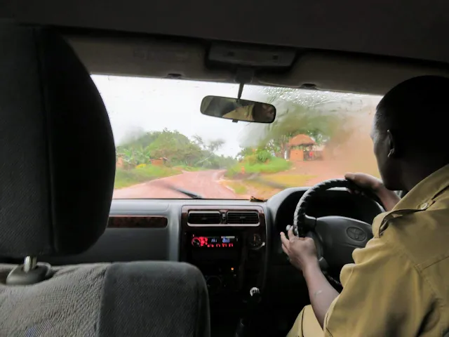 Geoffrey Katende, our Matoke Tours guide driving on a red dirt road in Uganda