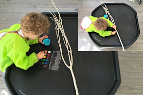 boy painting a stick on the tuff trau