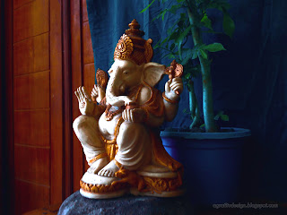 Right View Lord Ganesha Mini Statue On The Stone With Tiny Decorative Flower Plants In The Room 