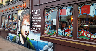 Supersized tacky Ed Sheerin mural advertisinh Fest red hair blue eyes beautiful man