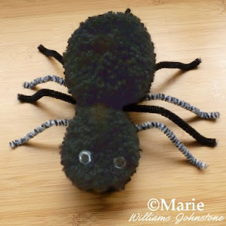 Black and gray fluffy yarn spider with googly eyes