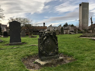 Gravestone in chapel grounds with Marionville Fire Station Tower in distance.  Photo by Kevin Nosferatu for the Skulferatu Project