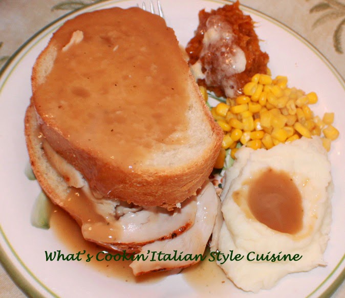 Italian Covered Turkey Sandwich this is gravy with turkey covered sandwich with gravy mashed potatoes, corn and sweet potatoes on the plate